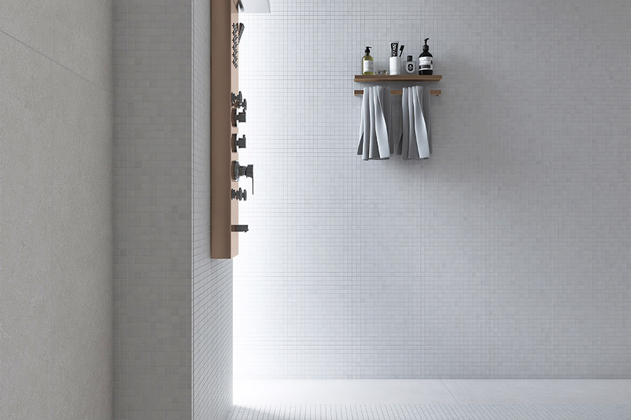 Minimalist walk-in shower with white square tiles on both walls and floor.