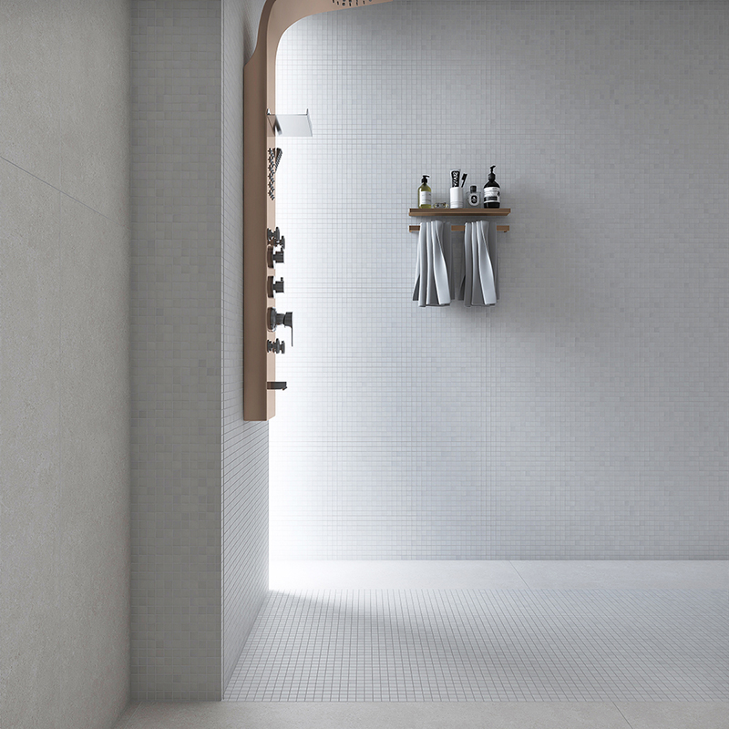 Modern shower wall featuring white square mosaic tiles and copper fixtures.
