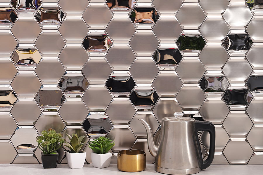 Wide view of stainless steel 3D hexagon backsplash showcasing kettle, small planters and gold cup