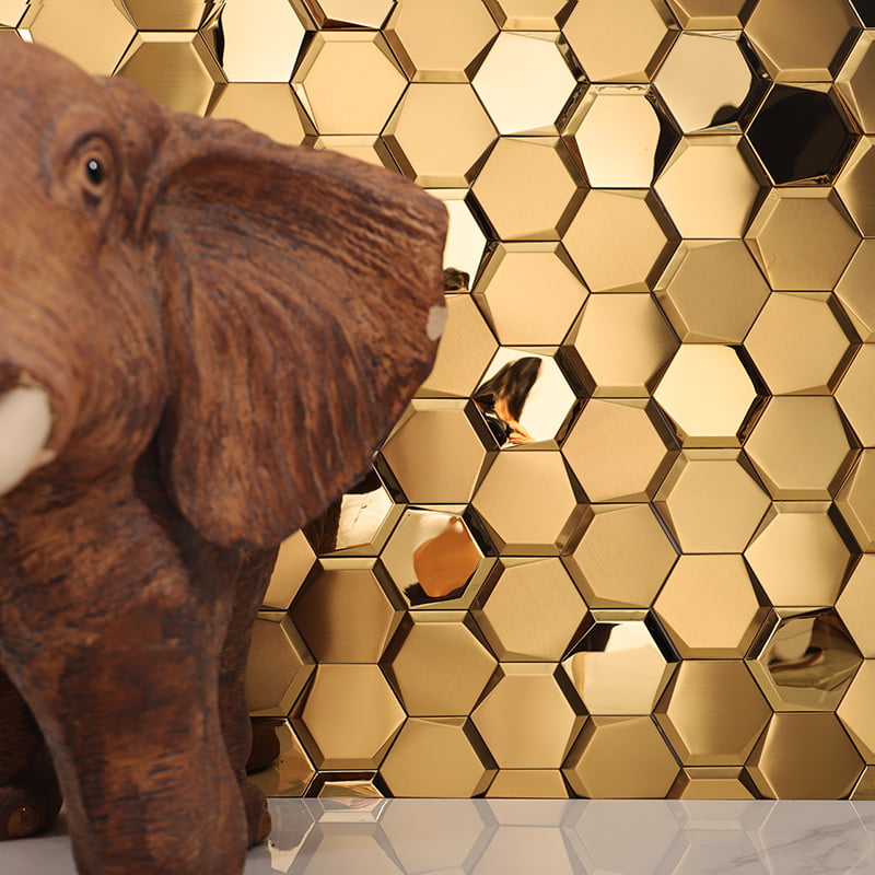 Close-up of a carved wooden elephant statue in front of reflective gold hexagon metal tiles