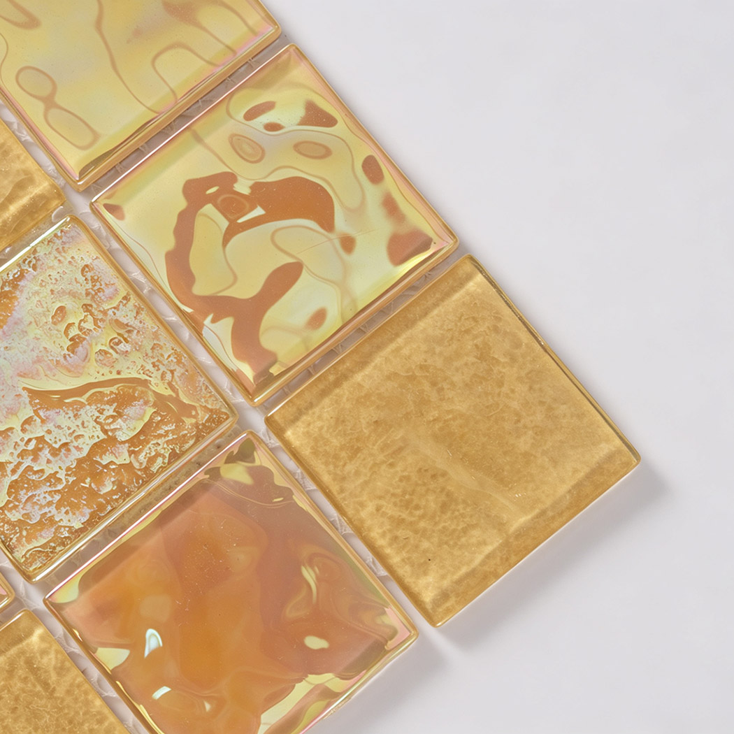 Corner close-up of yellow iridescent square glass mosaic tiles with warm amber tones