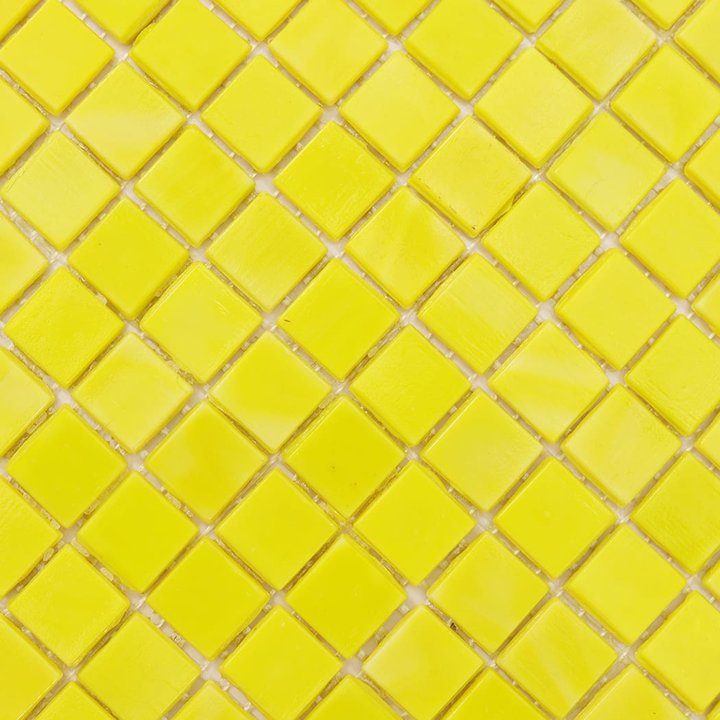 Close-up view of lemon yellow square glass mosaic tile surface texture