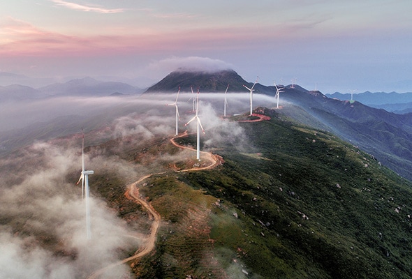 Wind turbines on a misty mountaintop convey Lenovo's commitment to sustainable technology and the need to decrease any harmful impact on the planet.