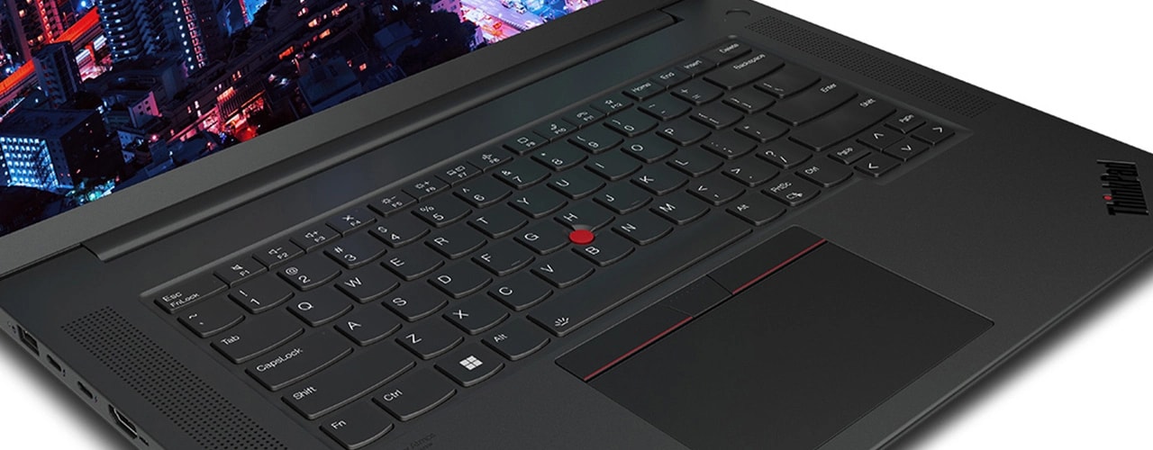 Close up of Lenovo ThinkPad P1 Gen 6 (16″ Intel) mobile workstation, opened at an angle, showing part of keyboard & part of display with a night skyscraper scene