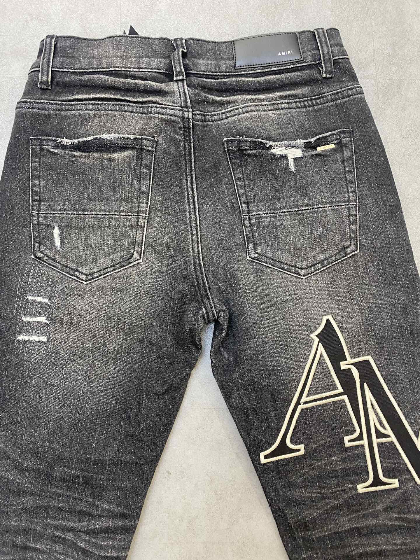 AMIRI jeans with a distressed finish, embroidered logo on the side (ADS050-033）