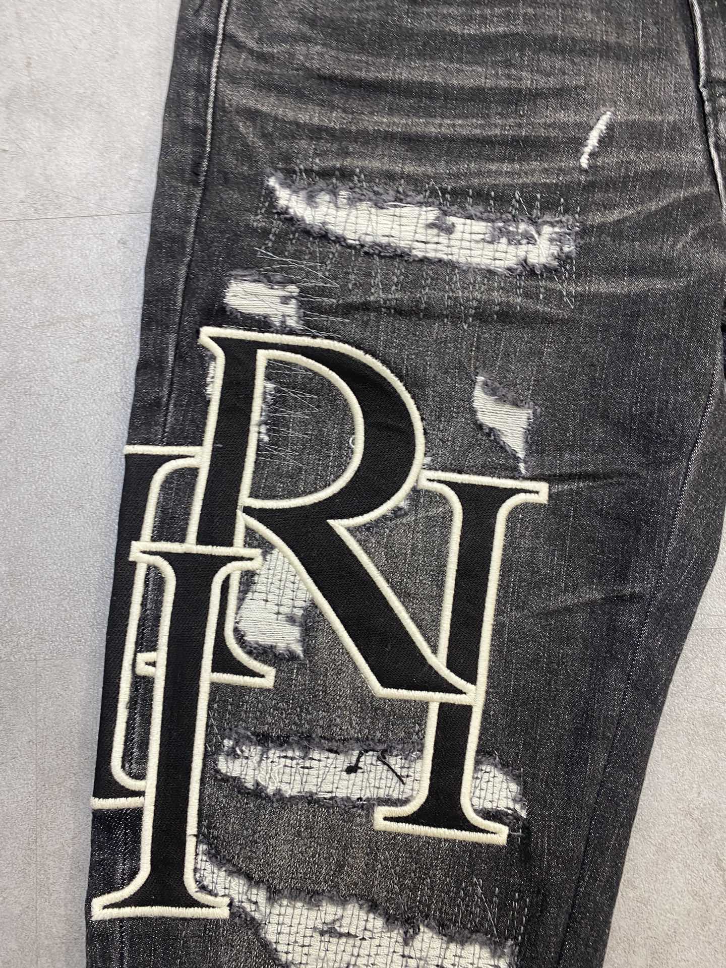 AMIRI jeans with a distressed finish, embroidered logo on the side (ADS050-033）