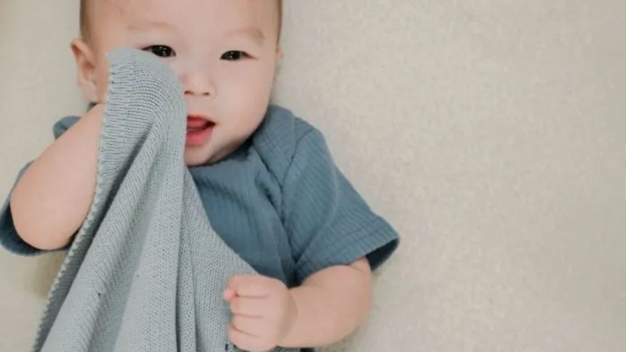 A newborn in a cozy, safe, and soft blanket in a wooden box