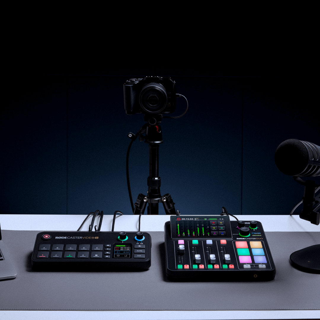 Person using PodMic USB and R&Oslash;DECaster Video desk setup