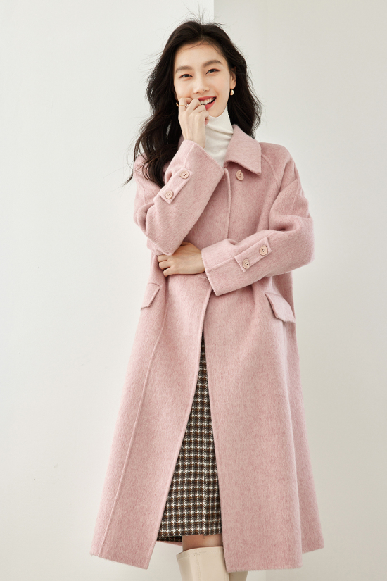 Woman wearing a pastel pink wool coat in winter