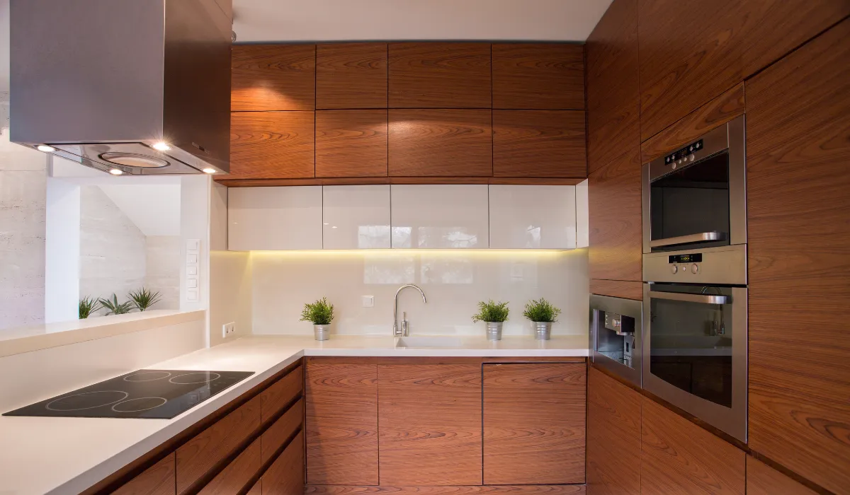 Contemporary kitchen with wood cabinets, glass backsplash, and under-cabinet lighting.