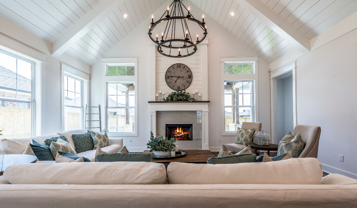 Cozy living room with a vaulted ceiling, large chandelier, and fireplace centerpiece ideal for homes with high ceilings.