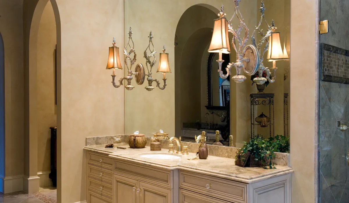 Luxurious bathroom with ornate wall sconces and chandeliers, adding elegance and warmth.