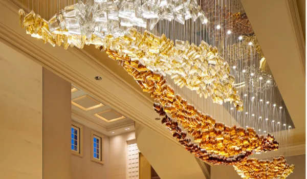 Luxurious statement chandelier with gold and glass details in a grand interior.