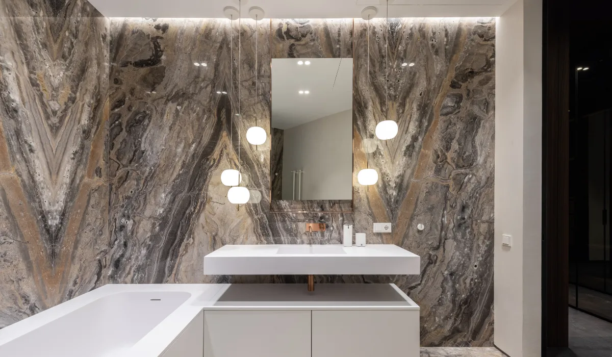 Bathroom with layered lighting and marble wall finishes