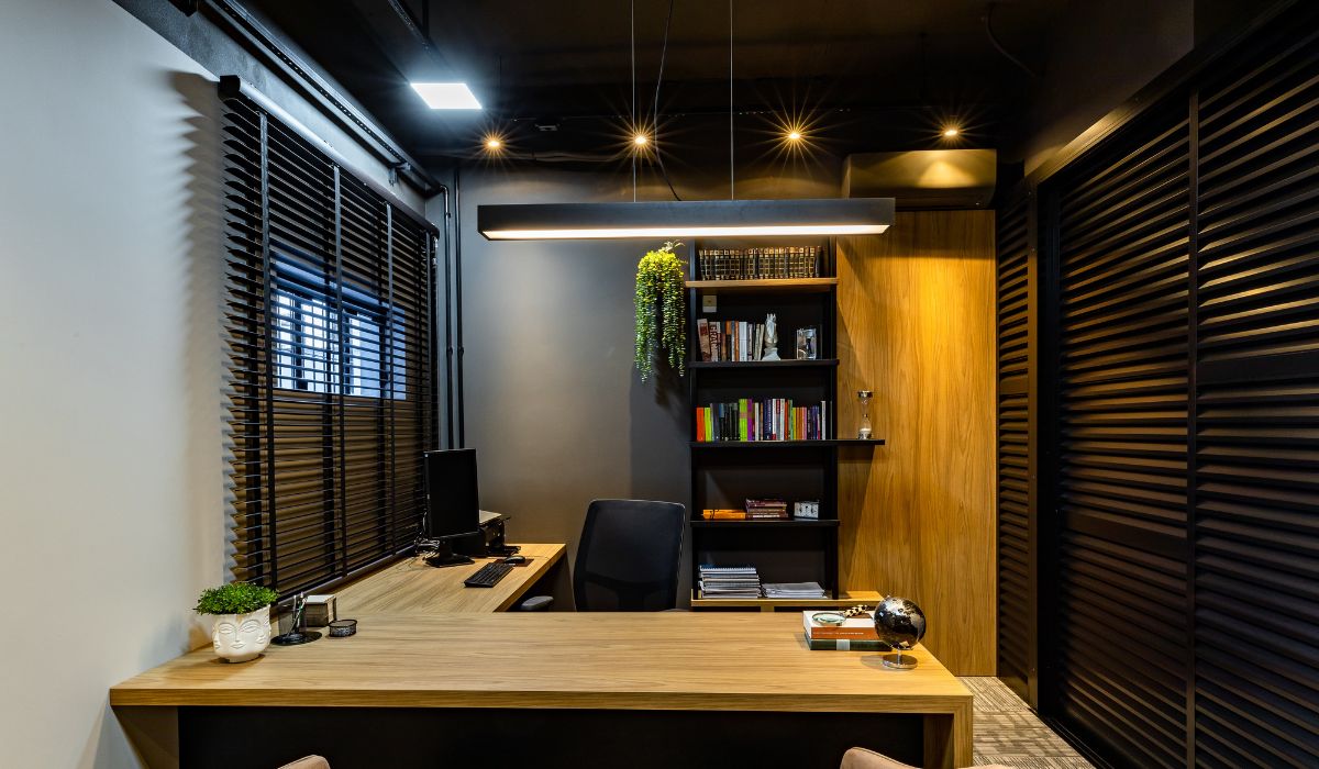 Modern home office with sleek pendant lighting, wood accents, and built-in bookshelves.