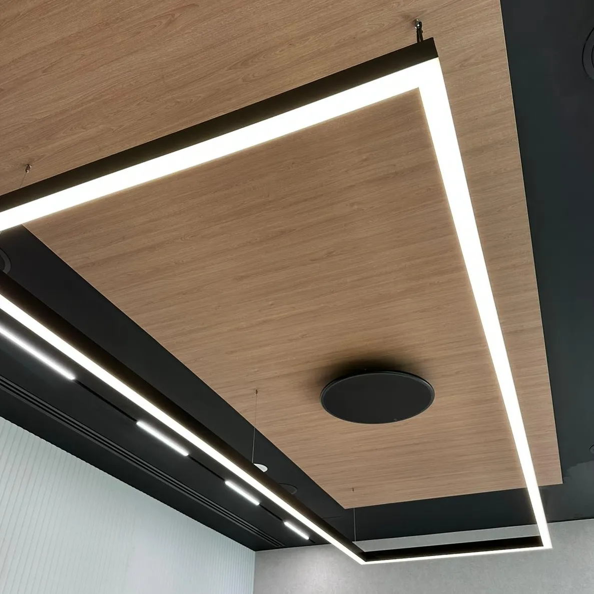 LED panel lighting integrated into a wooden ceiling for a sleek office design.