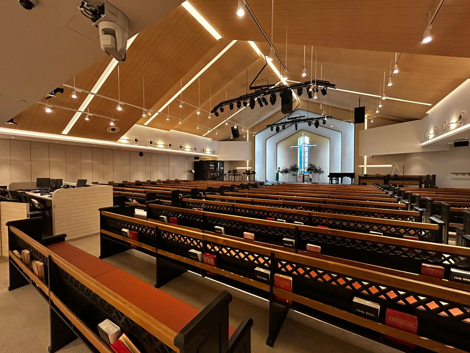 Modern church interior with warm lighting and LED track lights enhancing the worship space.