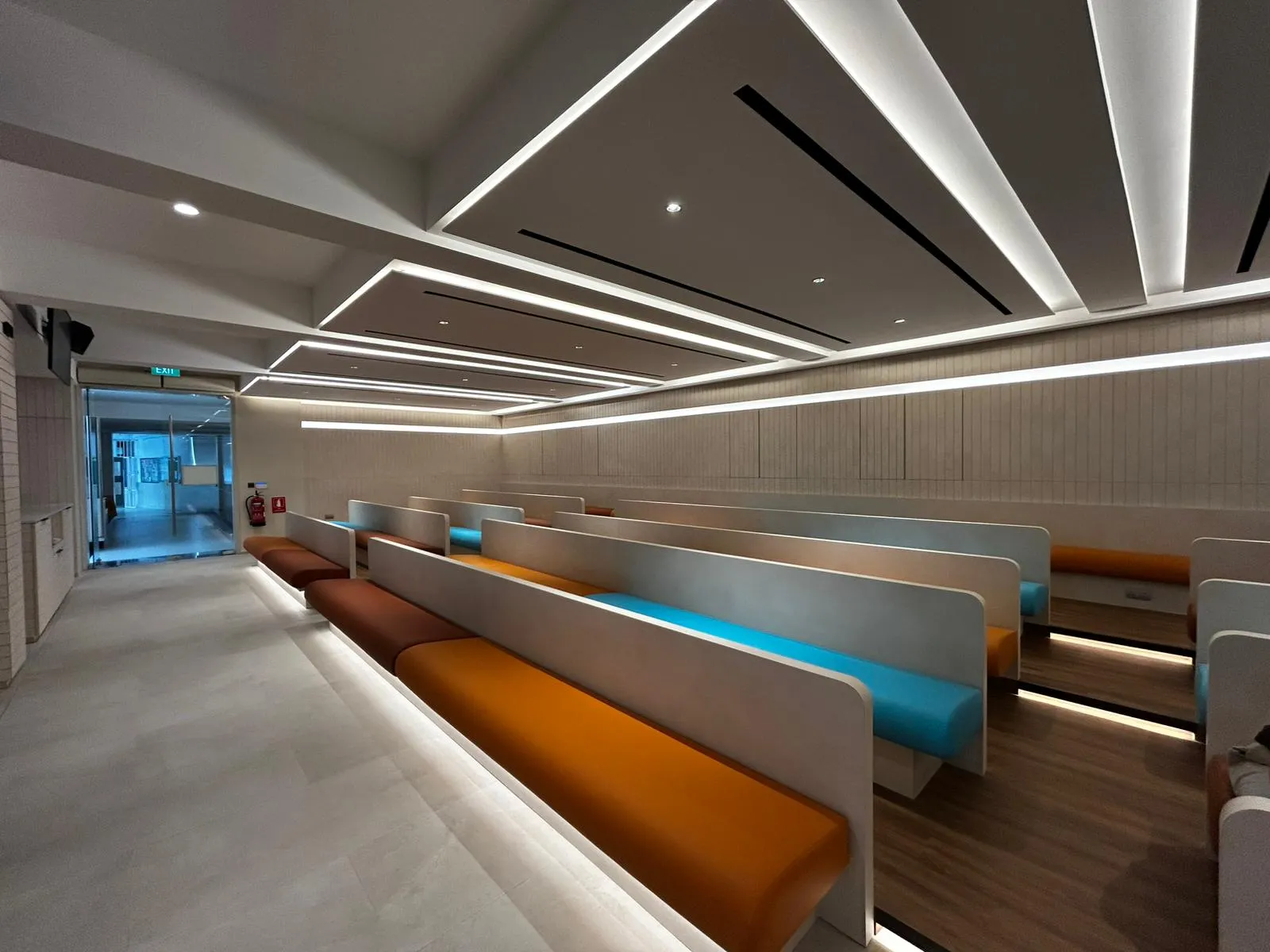 Church seating with recessed ceiling lights and warm under-bench illumination.