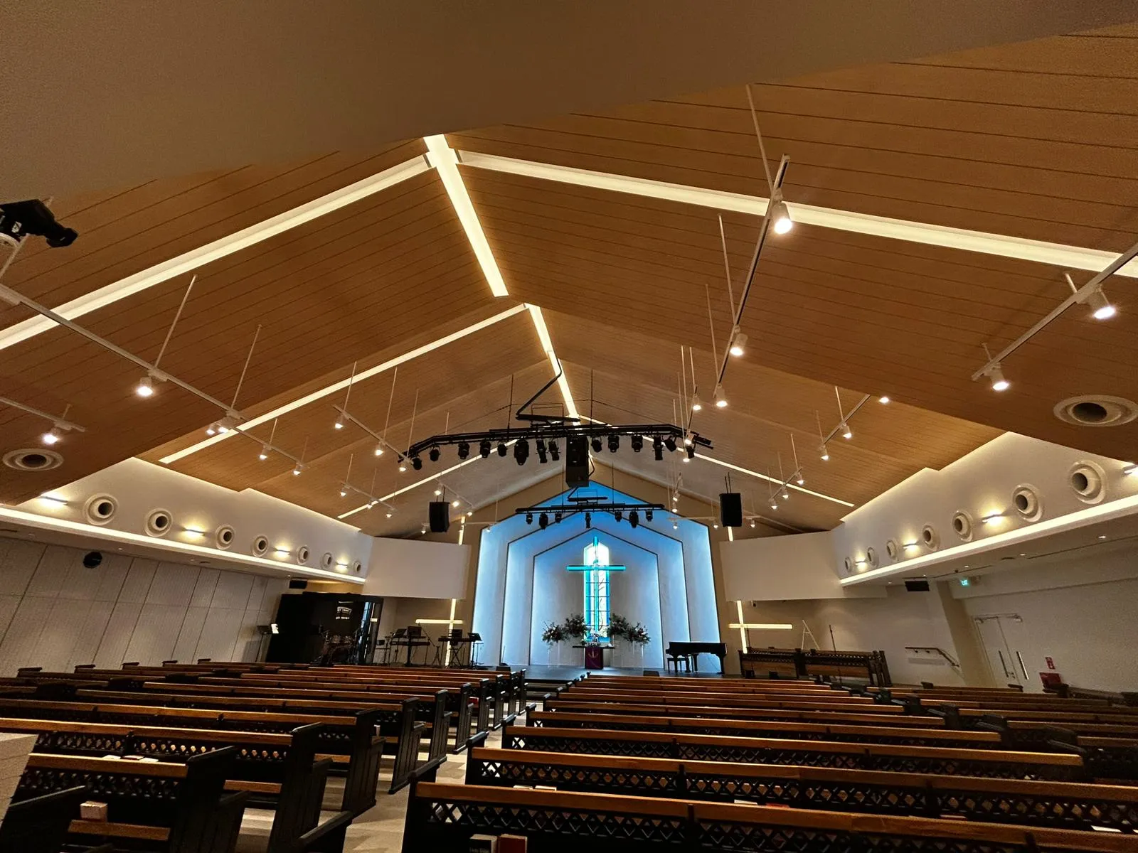 Church ceiling with recessed and track lighting enhancing the wooden panels.