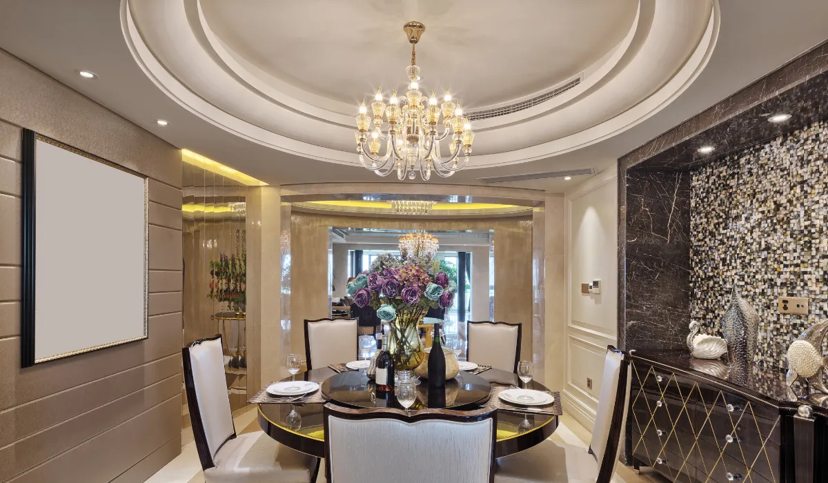 Luxurious dining room with chandelier, round table, and floral centerpiece under a domed ceiling.
