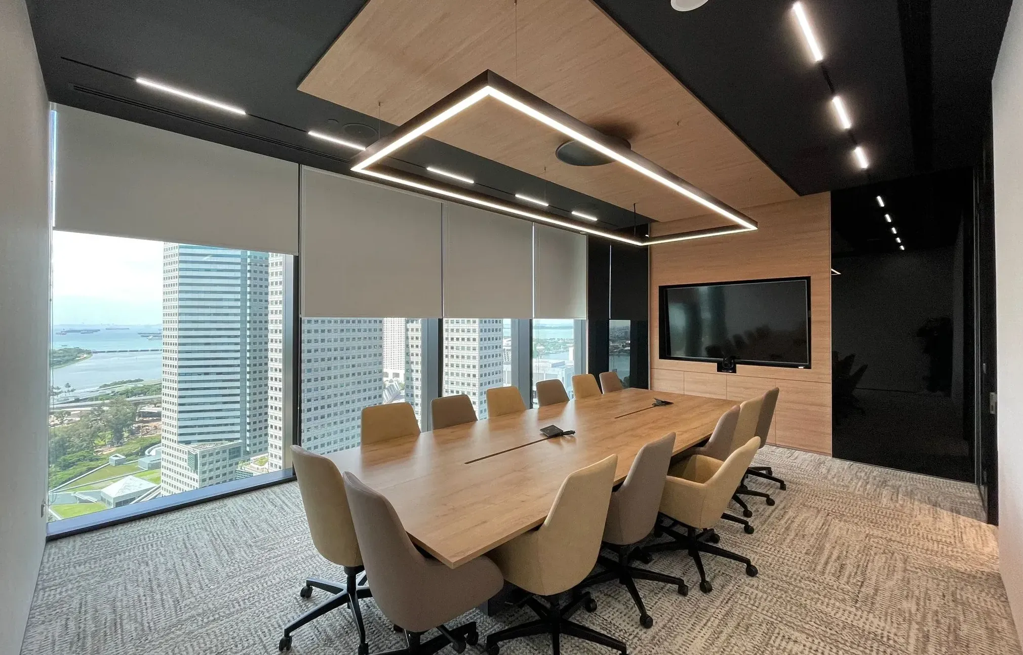 Modern conference room with LED panel lighting and recessed track lights.