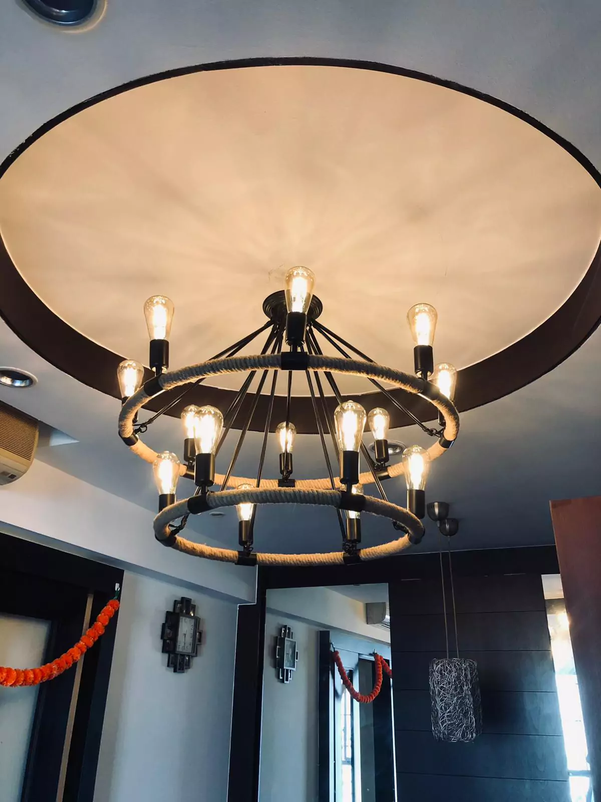 {"default":"Elegant French-style chandelier featuring a large circular fabric shade with a dark metal frame supporting multiple exposed bulbs. "}