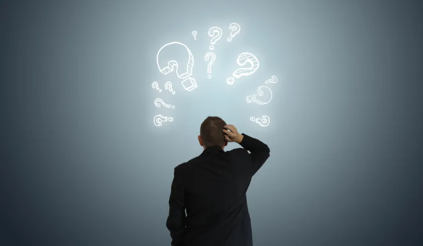 Man scratching head with question marks drawn above