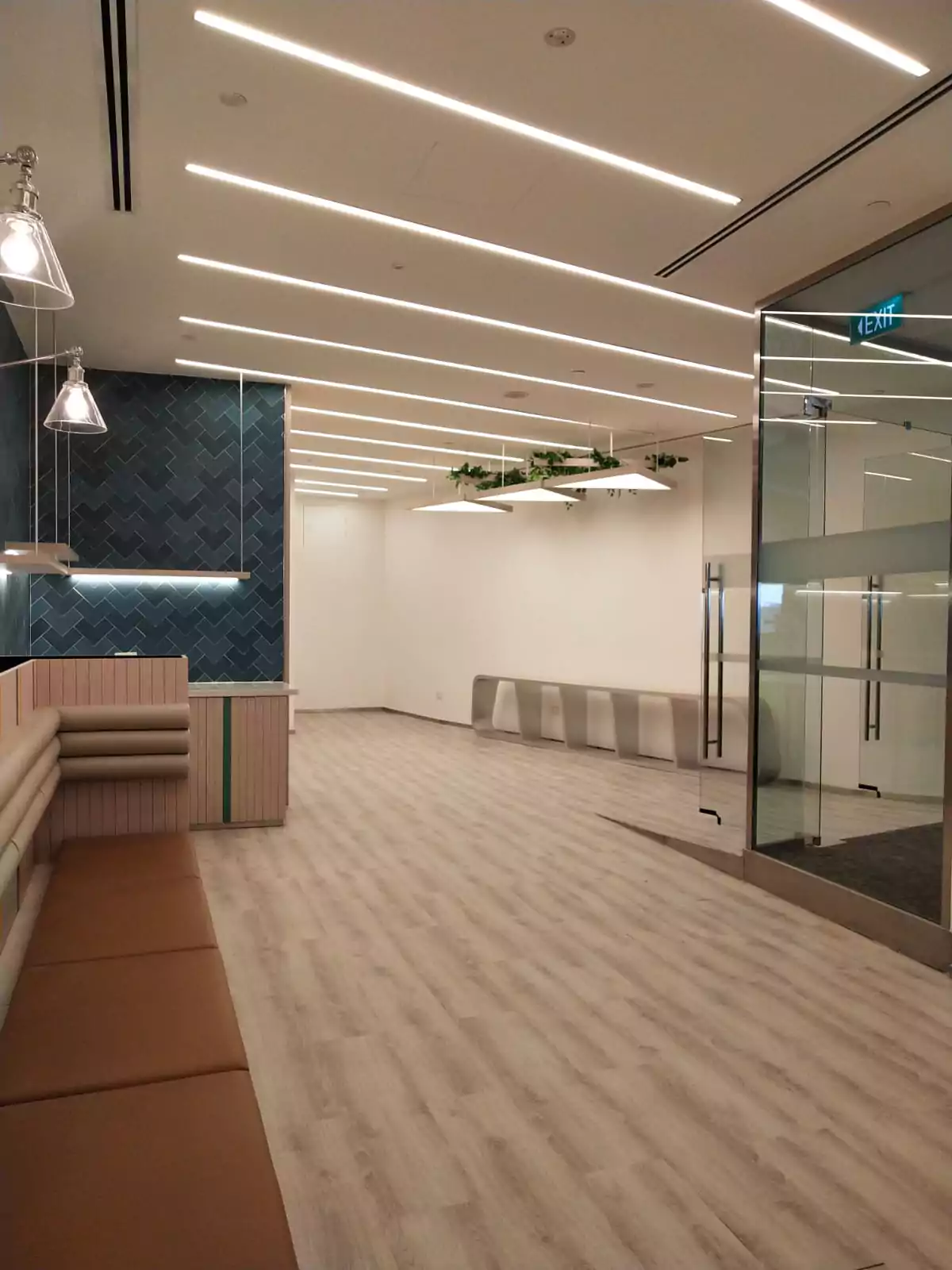 {"default":"Modern office corridor featuring sleek LED strip lighting recessed into the ceiling, casting a bright linear glow over the space. "}
