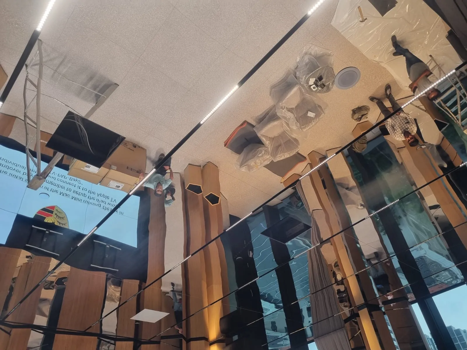 Reflective showroom ceiling with recessed tracklights enhancing depth and ambiance.