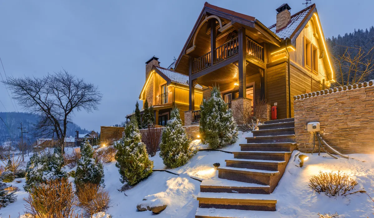 Modern house with outdoor lighting glowing in snowy winter setting