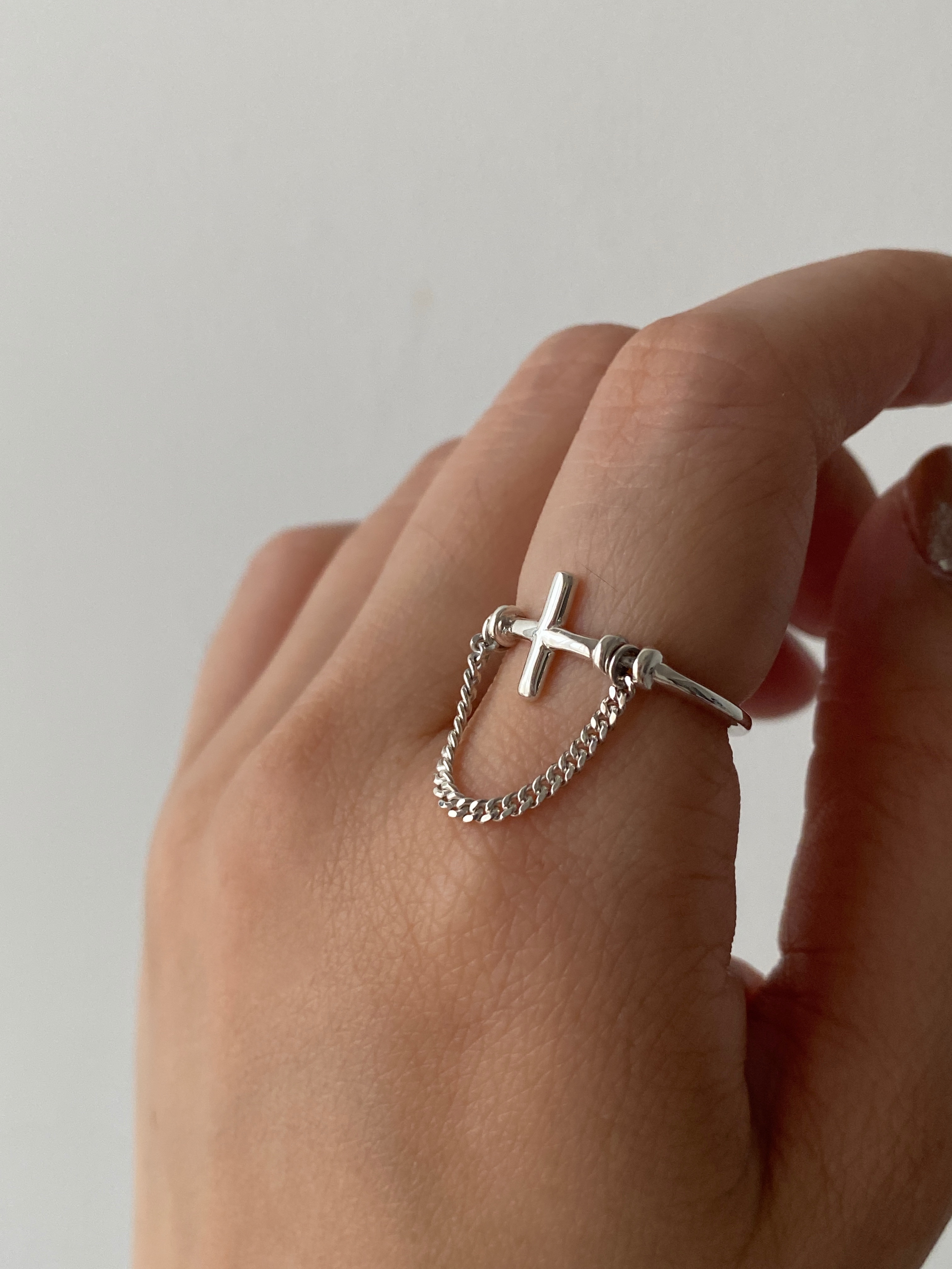Cross with dangling chain ring