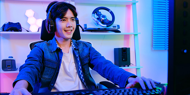 A young man playing video game on a computer