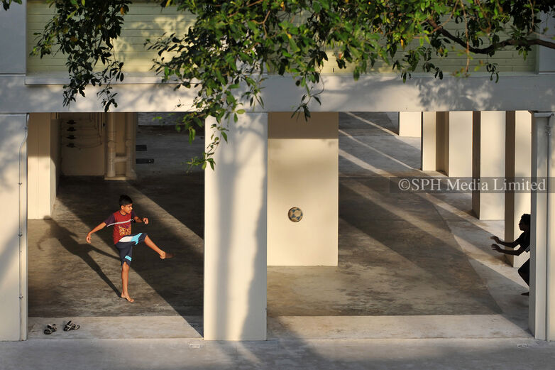Playing football at HDB void deck, 2012 Print
