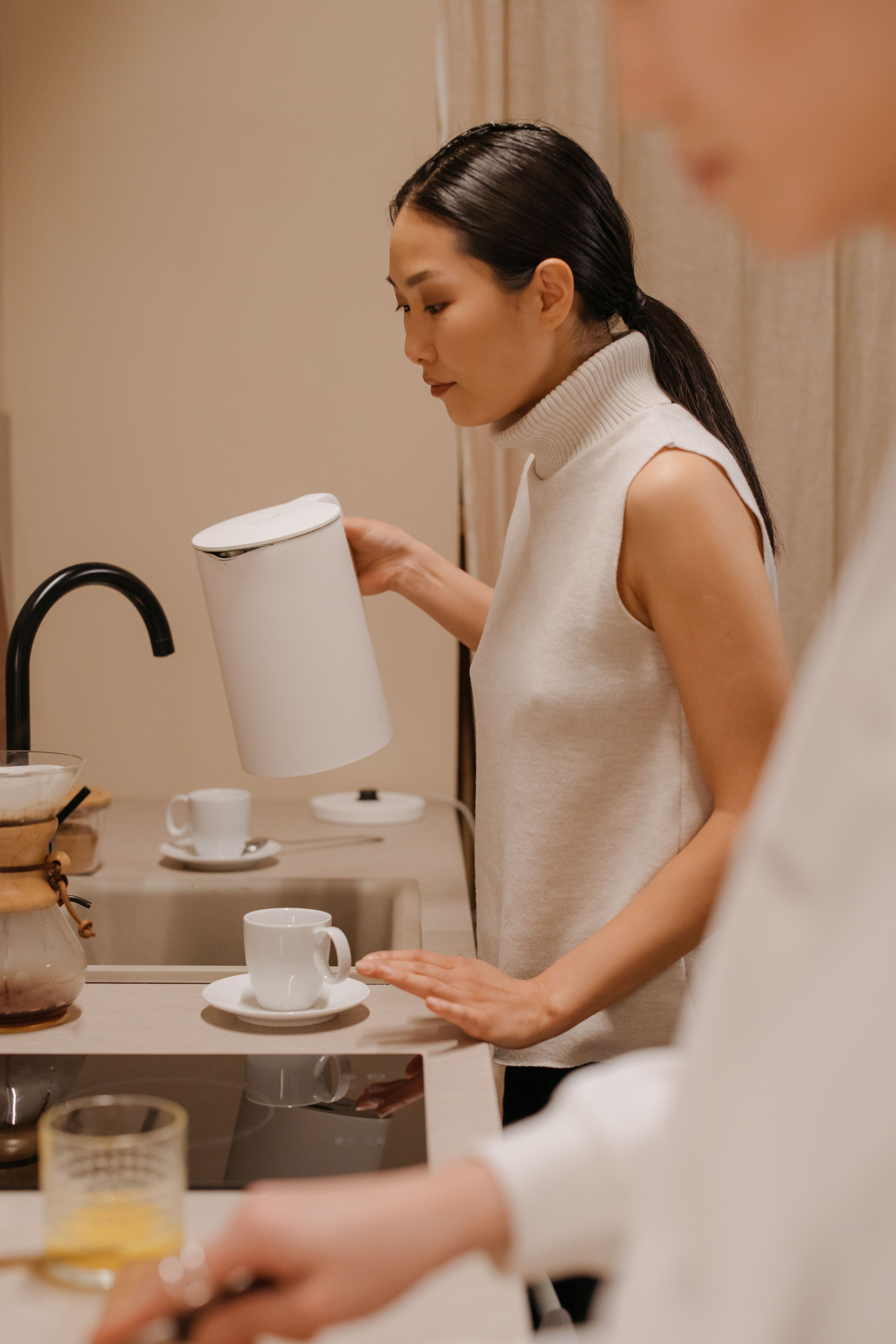 VEIMIA Asian woman making tea with a friend as part of ordinary life and support