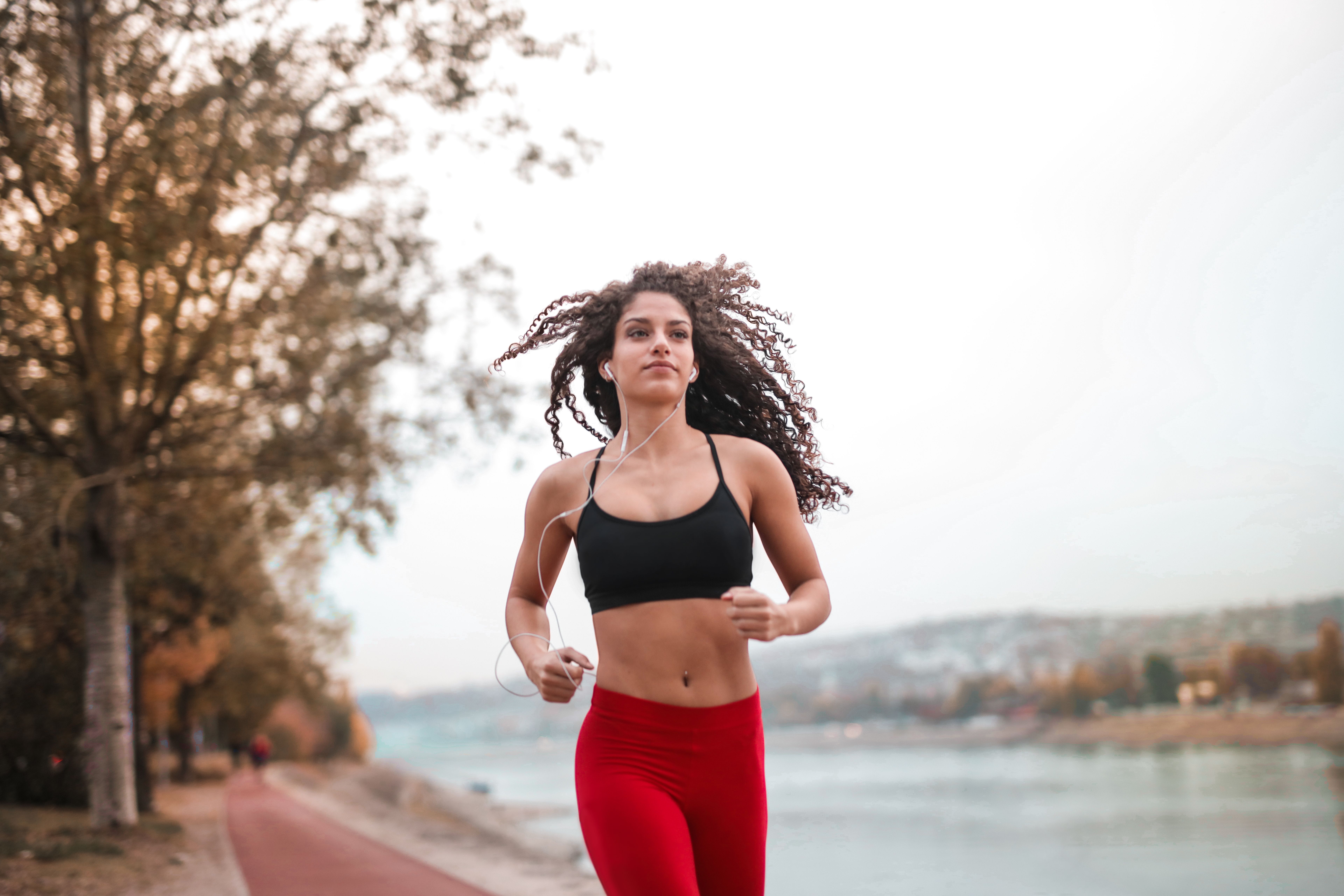 女性穿運動內衣在戶外慢跑，提醒跑步 Sports Bra 要選防晃和排汗快乾設計