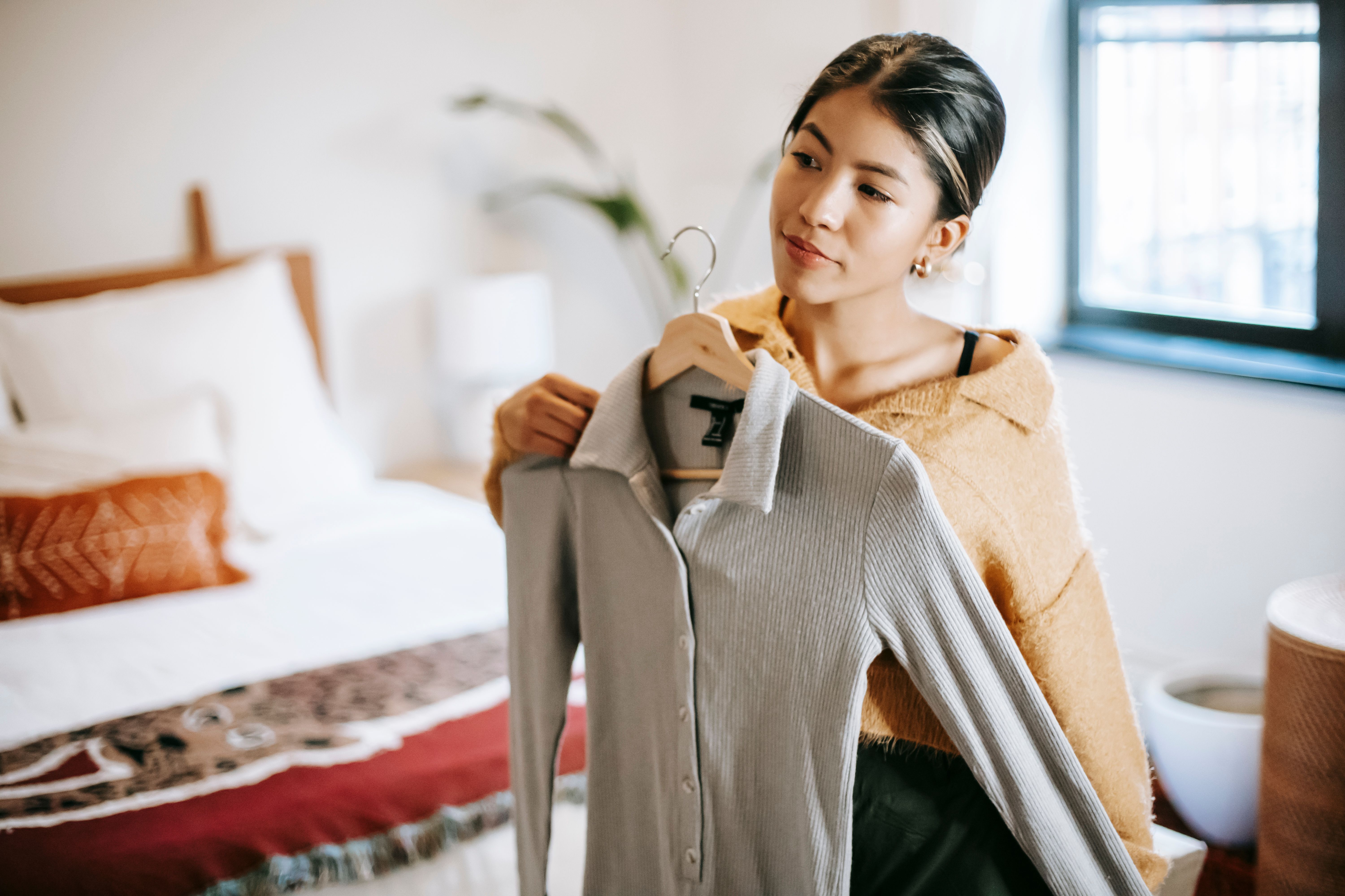 VEIMIA Asian woman selecting a soft everyday blouse while dressing after mastectomy