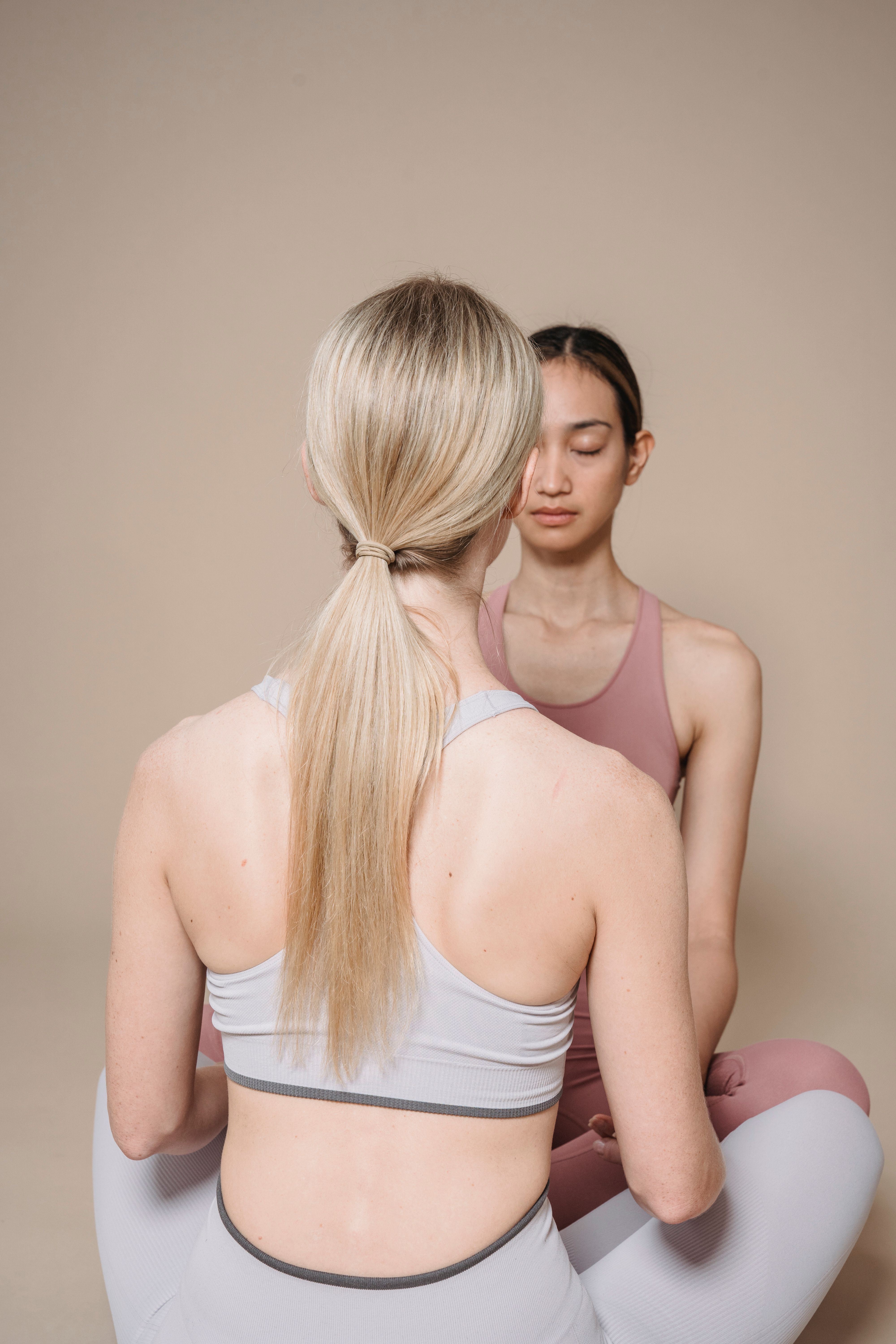 VEIMIA women in sleek activewear in a calm neutral yoga studio