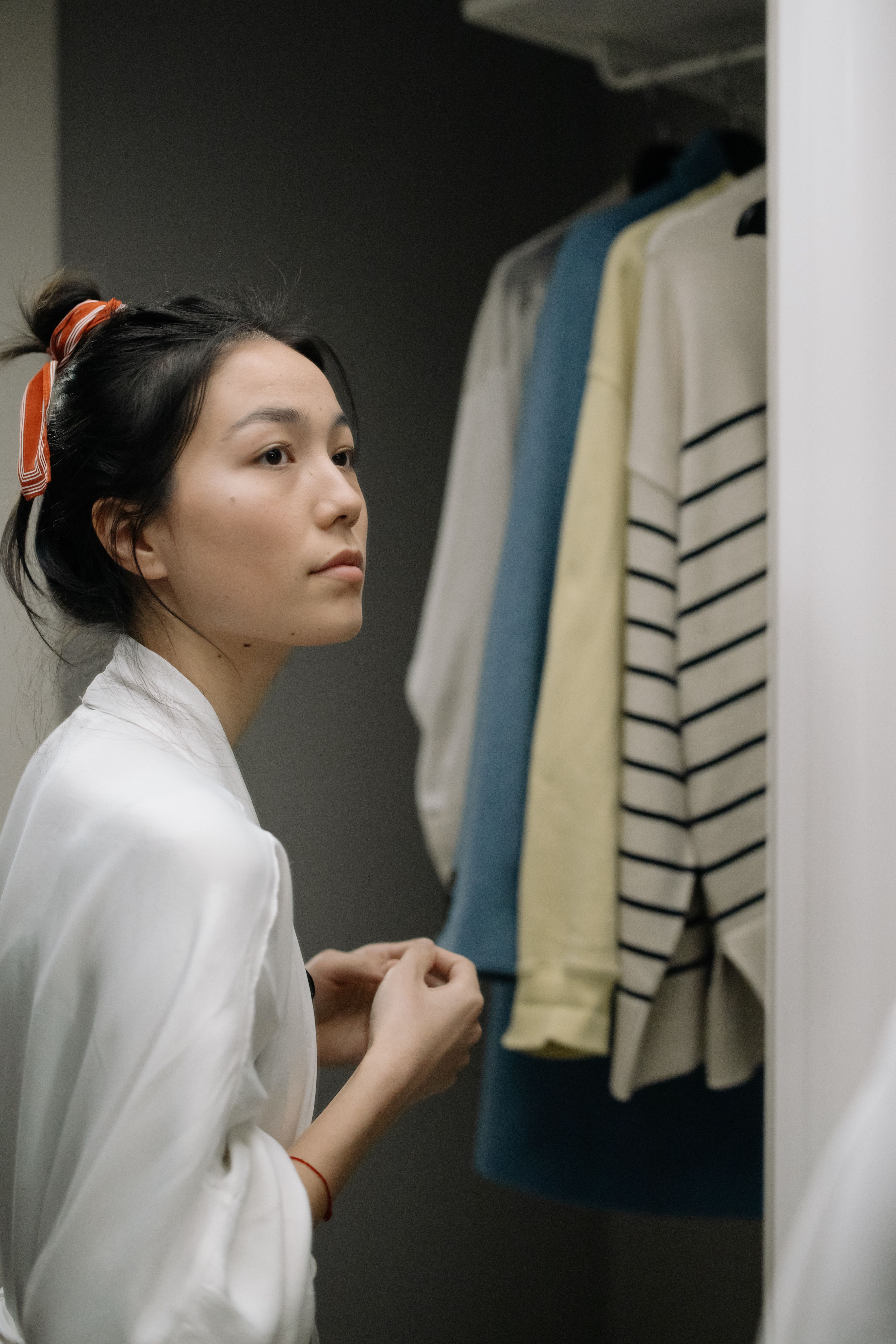 女性在衣櫃前選擇衣物，象徵青春期女生需要被尊重的穿衣安全感