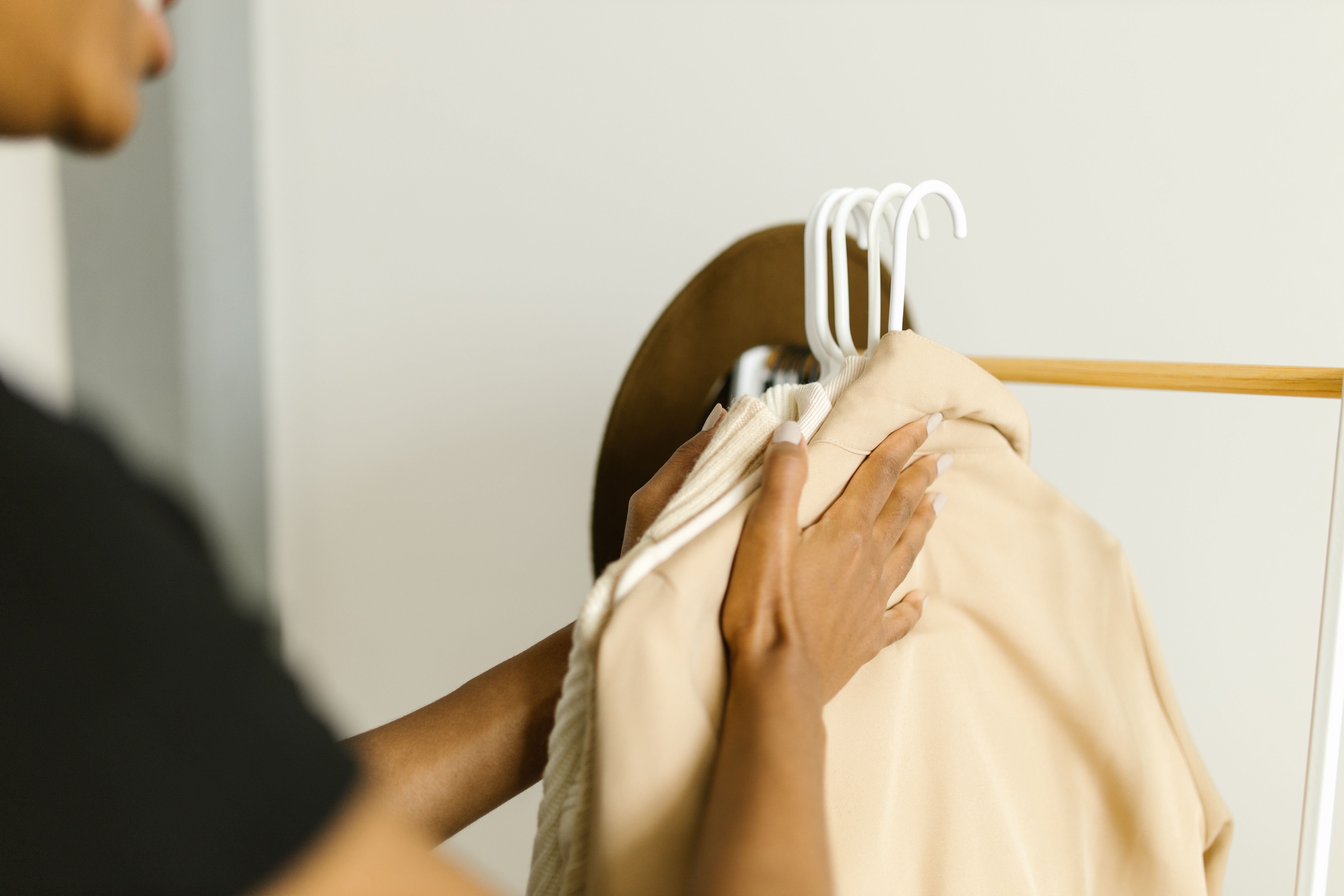 VEIMIA hands arranging soft neutral clothing for comfortable dressing after mastectomy