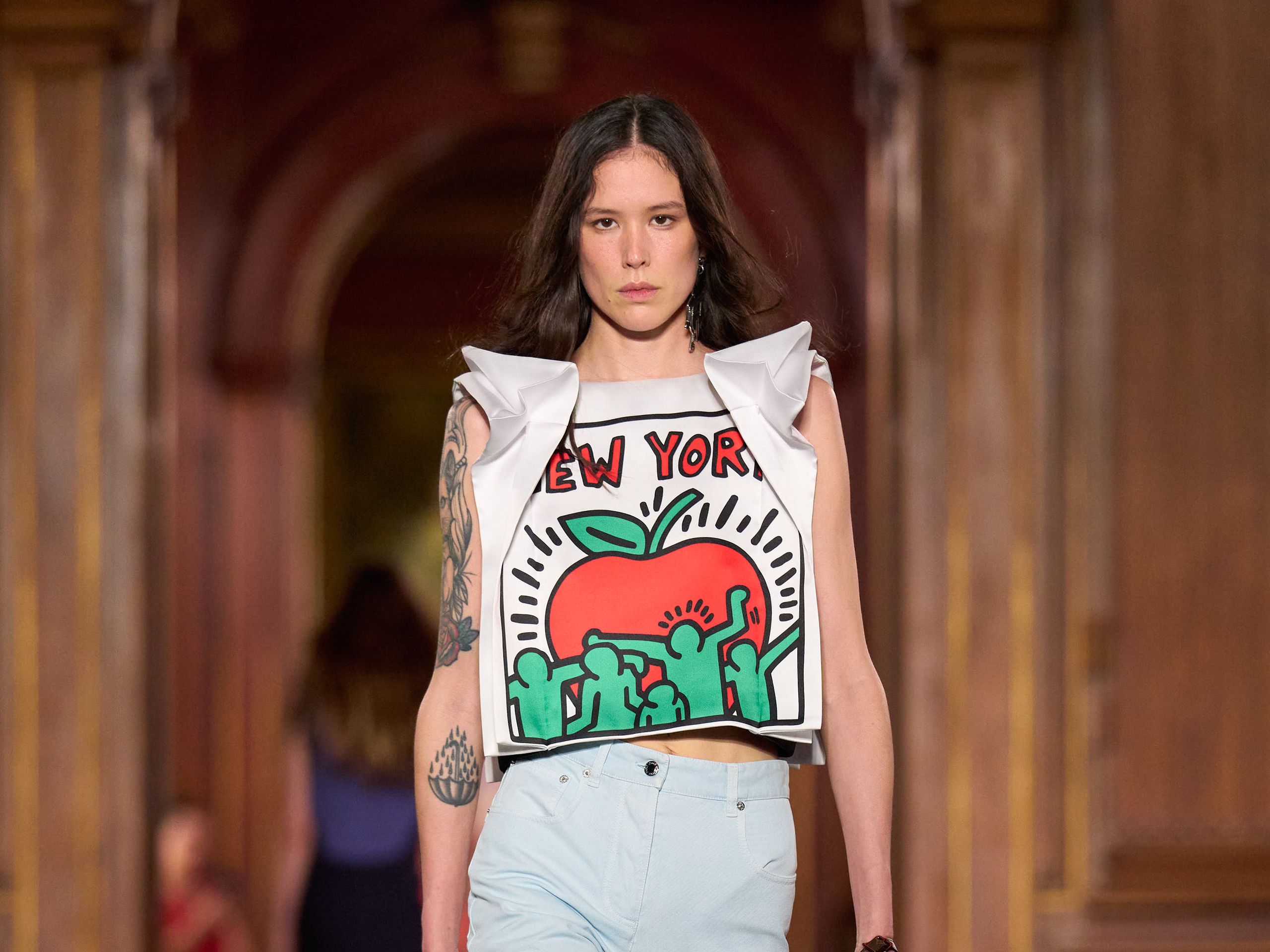 Louis Vuitton Resort 2027 秀場造型，Keith Haring 紐約圖像上衣與淺色褲裝