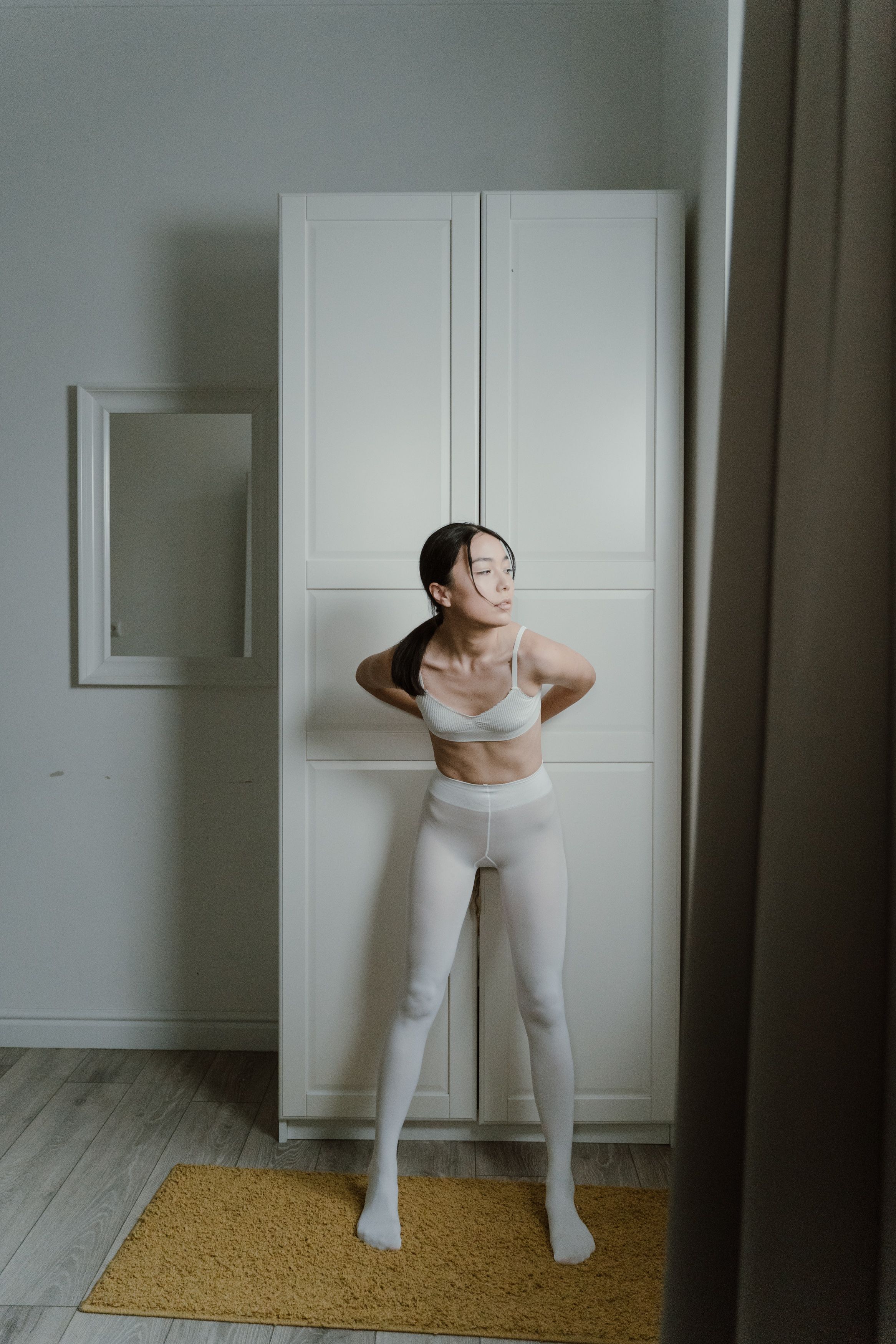 VEIMIA Asian woman adjusting a comfortable bra beside her wardrobe to check movement and fit