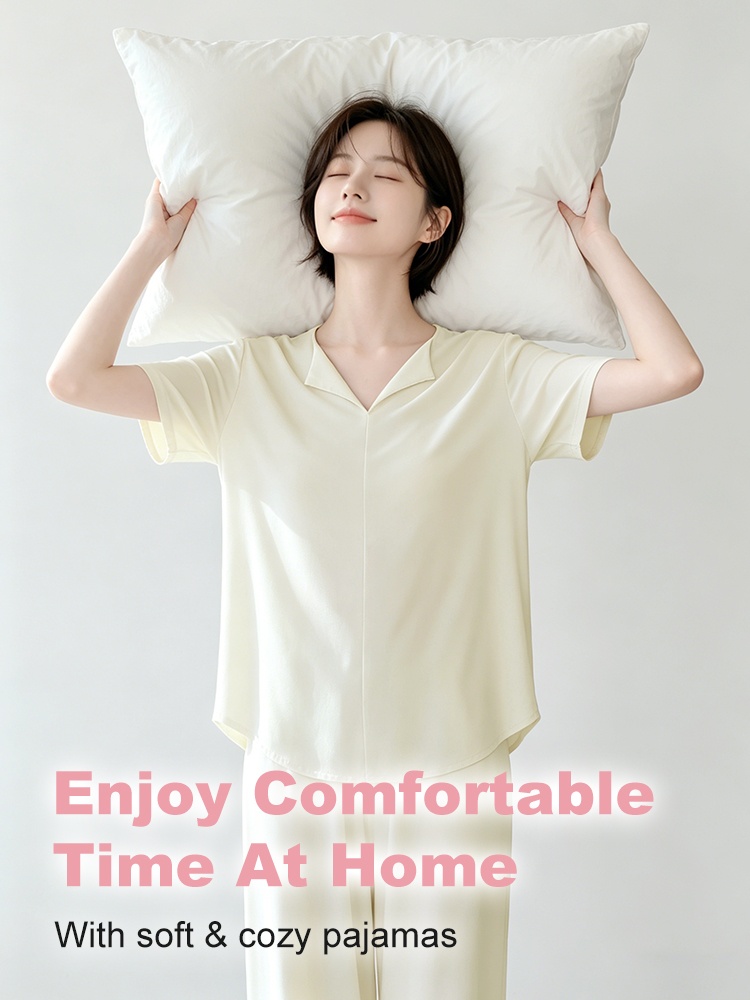 Model wearing a light yellow pajama set while holding a pillow at home - VEIMIA