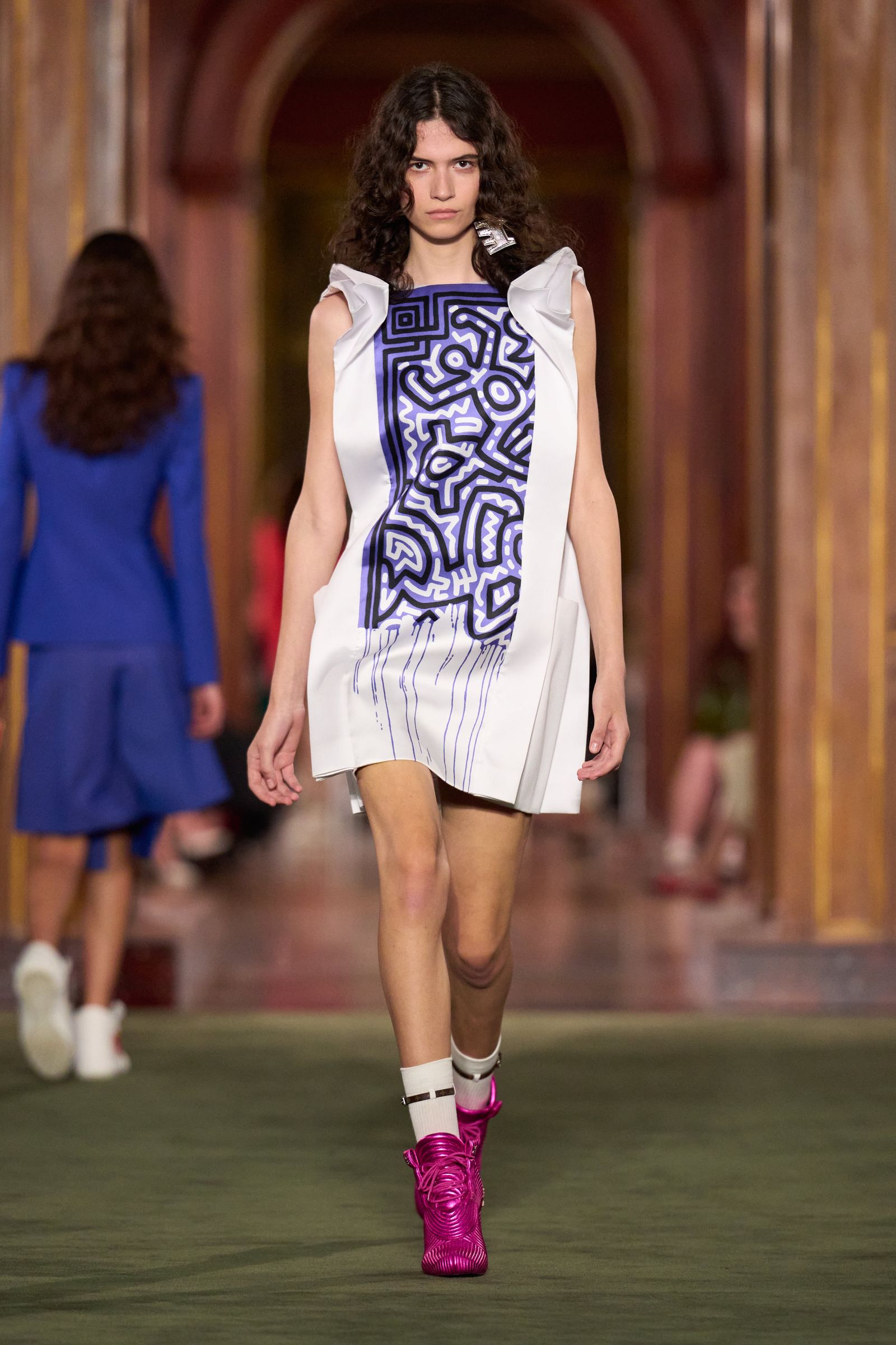 Louis Vuitton Cruise 2027 白色短裙造型搭配藍色 Keith Haring 風格圖案