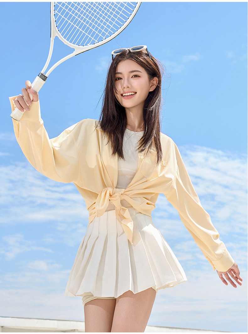 Model wearing yellow UV sun protection jacket tied at the waist outdoors - VEIMIA