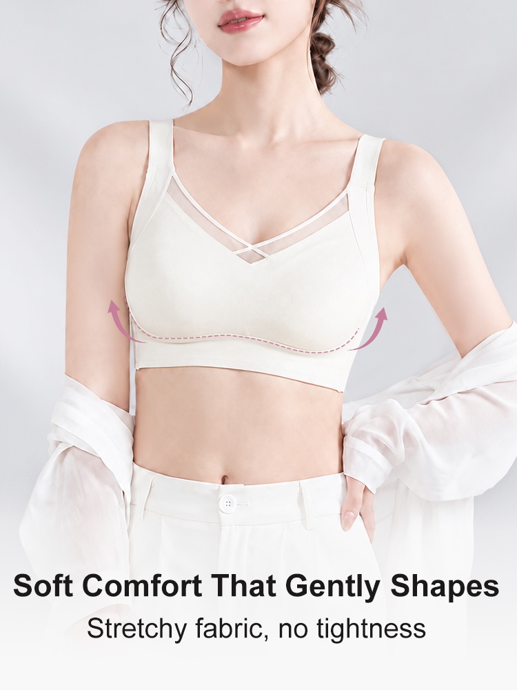 Model wearing champagne wireless bra with crossover neckline and support arrows VEIMIA
