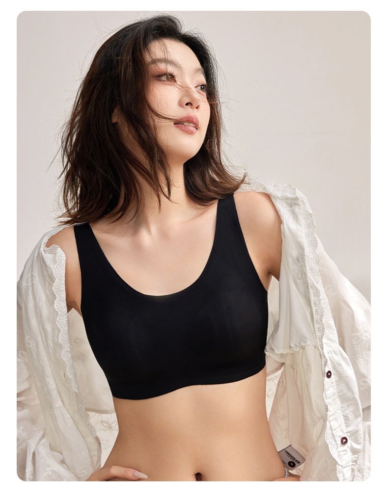 Model wearing black seamless bra with wide straps under open white blouse VEIMIA
