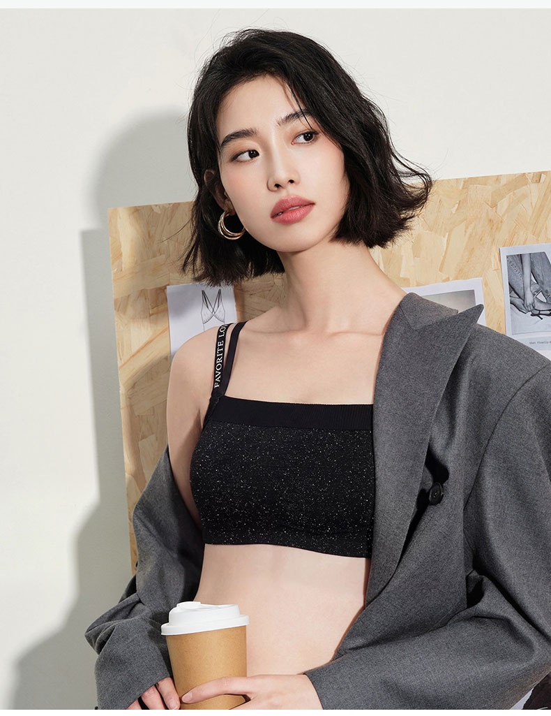 Model wearing black bra with gray blazer and holding coffee cup VEIMIA