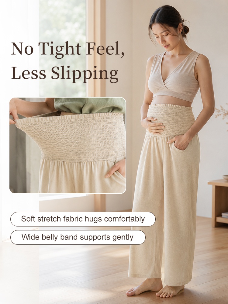 Pregnant model showing soft stretch belly band on beige wide-leg maternity pants VEIMIA