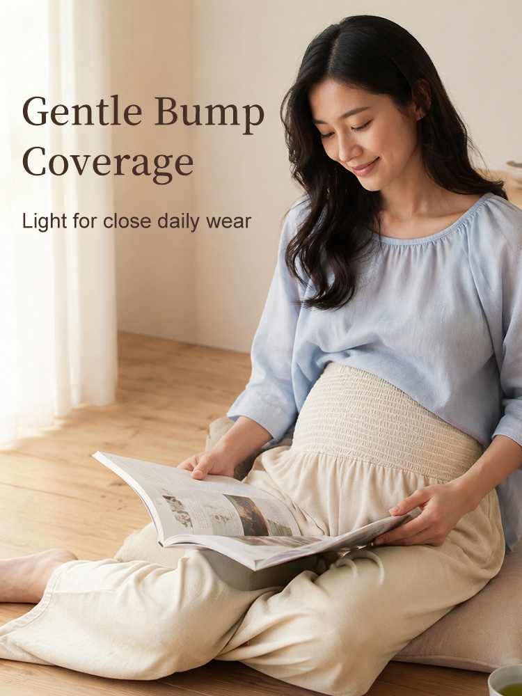 Pregnant model reading while wearing beige high-waist wide-leg maternity pants VEIMIA