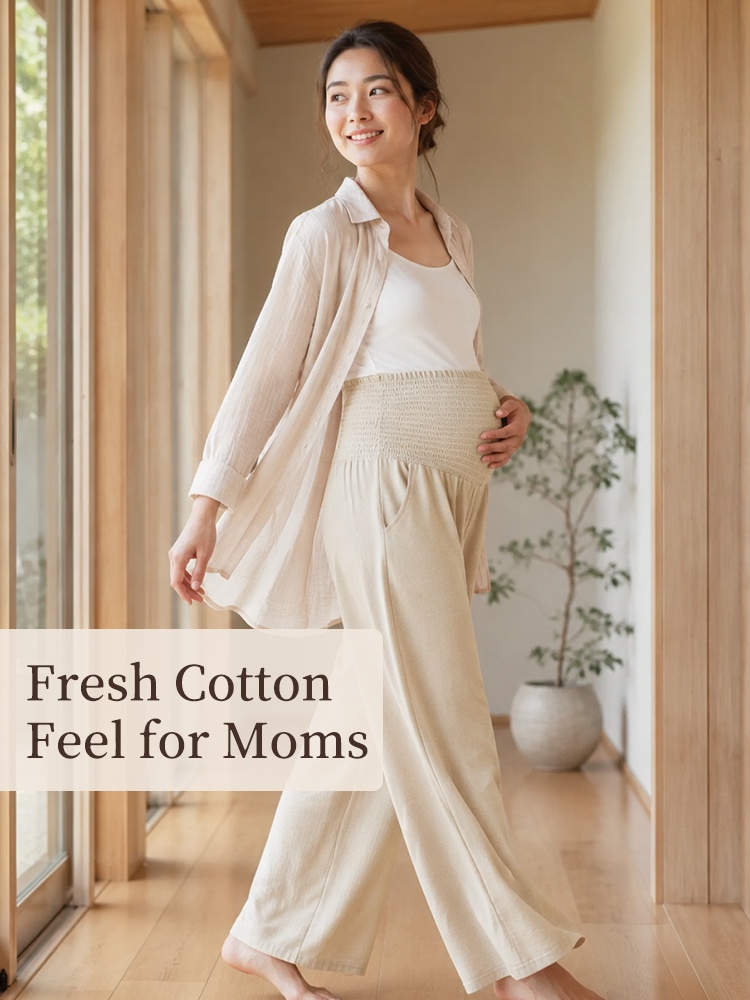 Pregnant model walking indoors in beige wide-leg maternity pants with belly panel VEIMIA